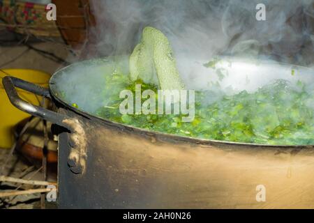 Brassica Blätter in kochendem Wasser, Wasser blasen springen aus dem Wasser. Ein lokales Gericht aus Indien und Pakistan, der berufen ist, saag sarsoon. Stockfoto