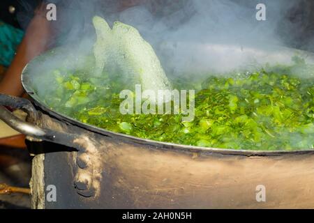 Brassica Blätter in kochendem Wasser, Wasser blasen springen aus dem Wasser. Ein lokales Gericht aus Indien und Pakistan, der berufen ist, saag sarsoon. Stockfoto