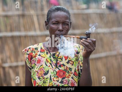 Porträt einer Larim Stamm Frau Rauchen einer Pfeife, Boya Berge, Imatong, South Sudan Stockfoto