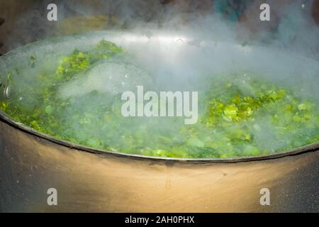 Brassica Blätter in kochendem Wasser, Wasser blasen springen aus dem Wasser. Ein lokales Gericht aus Indien und Pakistan, der berufen ist, saag sarsoon. Stockfoto