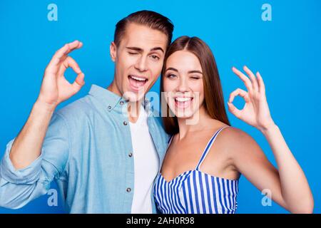 Close-up Portrait seiner er ihr, dass Sie zwei schöne attraktive schöne Inhalt Heiter Heiter froh Menschen umarmen, OK-Zeichen blinkende isoliert über Stockfoto