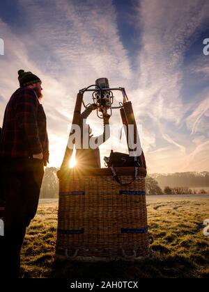 Ein Heißluftballon für Flug auf einem sonnigen frostigen Morgen im East Sussex, UK vorbereitet Stockfoto