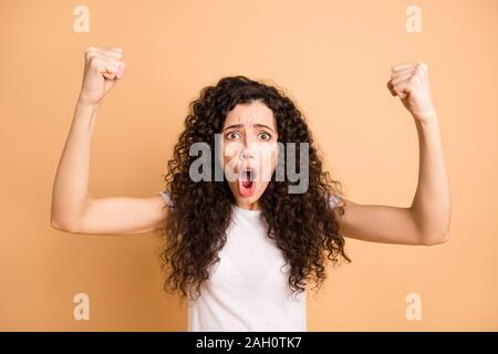 Nahaufnahme der erstaunlichen wellig Dame heben die Hände Fäuste verrückt schreien Fußball Team Wear casual Outfit beige Pastellfarben isoliert Stockfoto