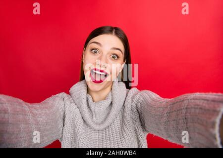 Ziemlich überglücklich Dame, selfies tragen in Form gestrickter Pullover rot Hintergrund isoliert Stockfoto
