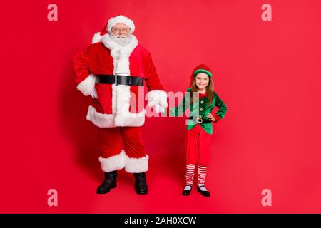 Volle Länge Foto von charmante Santa Elf in hat headwear halten sich an den Händen bereit Weihnachten Nacht tragen grüne Helle kostüm gürtel zu genießen isoliert Stockfoto