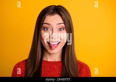 Foto von trendigen charmante süße nette attraktive faszinierende Freundin klemmt die Zunge heraus lächelnd toothily über gelb leuchtenden Farben isoliert Stockfoto