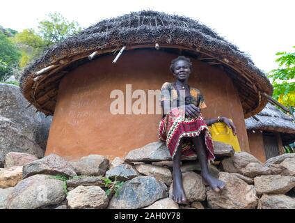 Frau sitzen vor einem lotuko Stamm Thatched House, Central Equatoria, Illeu, South Sudan Stockfoto
