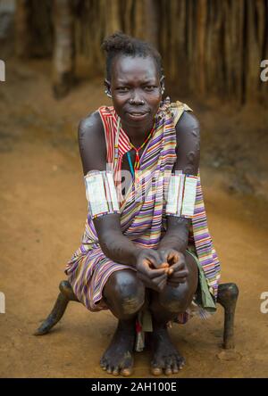 Porträt einer Larim Stamm Frau sitzen auf einem hölzernen Sitz, Boya Berge, Imatong, South Sudan Stockfoto