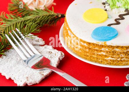 Christmas Cake, auf einer weißen Platte, auf einem roten Hintergrund Stockfoto