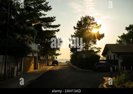 Sonnenuntergang auf einer Straße zum Meer in der Ferne Stockfoto