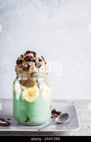 Vegan Banane Eiscreme mit Schokolade und Spirulina in einem Glas, kopieren. Stockfoto