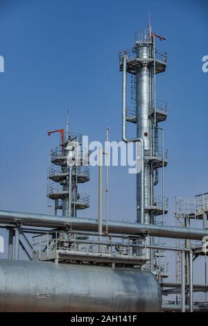 Grau Öl Raffinerieanlage Spalten in der Wüste auf den blauen Himmel. Stockfoto