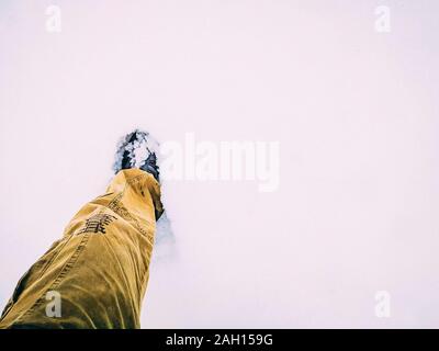 Füße trekking Stiefel wandern Reisende allein. winter Schuhe im Schnee, close-up der Ansicht von oben. Stockfoto