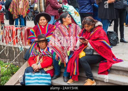 CUSCO, PERU - 26. JUNI 2019: Frauen in Trachten auf der Treppe sitzen, San Cristobal Celebracion Stockfoto