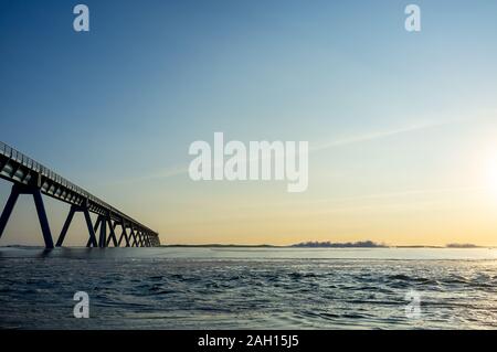 Wellen, die an der Atlantikküste in Frankreich durch Sonnenuntergang vor Wharf Stockfoto