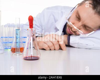 Erschöpft schlafen Wissenschaftler im Labor. Wissenschaft und Experiment im Labor Thema Stockfoto