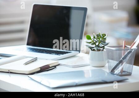 Nahaufnahme der Laptop mit leerer Bildschirm mit Notizen und Dokumenten, die auf der Tabelle im modernen Büro Stockfoto