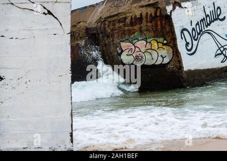 Beton Bunker aus Kriegszeiten Vergangenheit in Shorebreak auf Französisch Strand Stockfoto