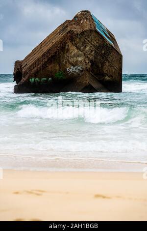 Beton Bunker aus Kriegszeiten Vergangenheit in Shorebreak auf Französisch Strand Stockfoto