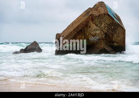 Beton Bunker aus Kriegszeiten Vergangenheit in Shorebreak auf Französisch Strand Stockfoto