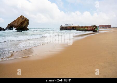 Beton Bunker aus Kriegszeiten Vergangenheit in Shorebreak auf Französisch Strand Stockfoto