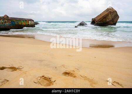 Beton Bunker aus Kriegszeiten Vergangenheit in Shorebreak auf Französisch Strand Stockfoto