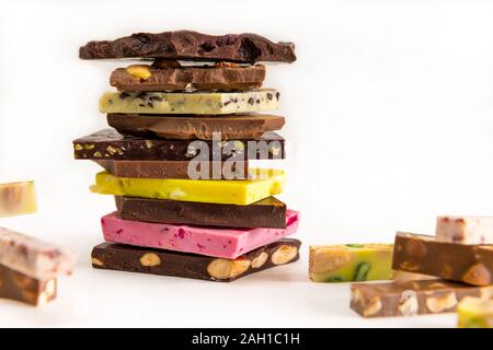 Verschiedene Arten von Schokolade auf einem Tisch werden übereinander gestapelt. Stockfoto