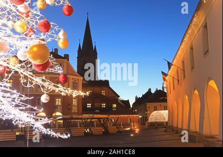 Weihnachten Dekorationen auf der Piata Mica mit St Mary's lutherischen Kathedrale, in der Altstadt von Sibiu/Hermannstadt in Siebenbürgen, Rumänien Stockfoto