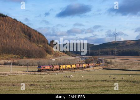 DB Cargo Klasse auf der West Coast Mainline in Schottland 66 Lok vorbei Elvanfoot mit einem Güterzug mit Materialien für Network Rail Stockfoto