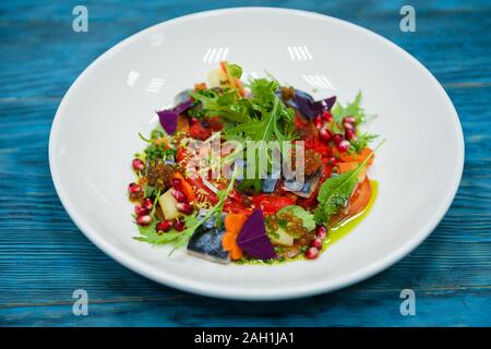 Escabeche Fischgericht mit Kaviar: Makrele in Marinade mit Gemüse, auf einem Schild auf dem Holz- blauen Hintergrund. Stockfoto