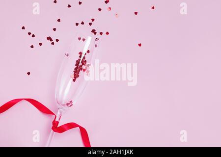 Sekt Glas mit snal Red Star geformt Konfetti auf rosa Hintergrund, Ansicht von oben Stockfoto