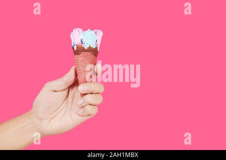 Hand mit leckeren Rosa und Blau Eis in der Waffel Mais Stockfoto