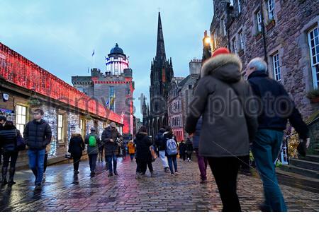 Edinburgh, Schottland, Großbritannien. 23. Dez 2019. Weihnachtsbeleuchtung und voll mit Touristen, die sich in der Royal Mile in der Abenddämmerung Ansätze. Blick auf die Camera Obscura. Quelle: Craig Brown/Alamy leben Nachrichten Stockfoto