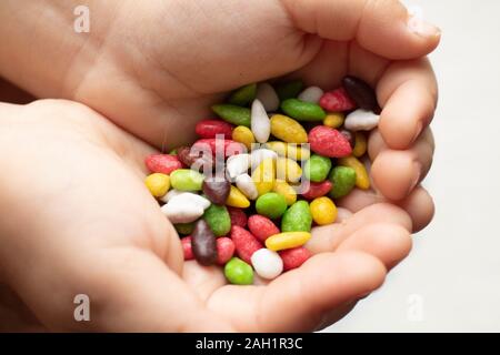 Mädchen, dass Candy süße Hintergrund. Bunte Sonnenblumenkerne in einem süßen Glasur close-up auf einem weißen Hintergrund als Textur. Stockfoto