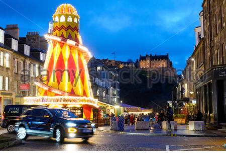 Edinburgh, Schottland, Großbritannien. 23. Dez 2019. Helter Skelter Weihnachten Kirmes in der Castle Street in der Abenddämmerung Ansätze. Blick auf das Schloss Edinburgh. Quelle: Craig Brown/Alamy leben Nachrichten Stockfoto