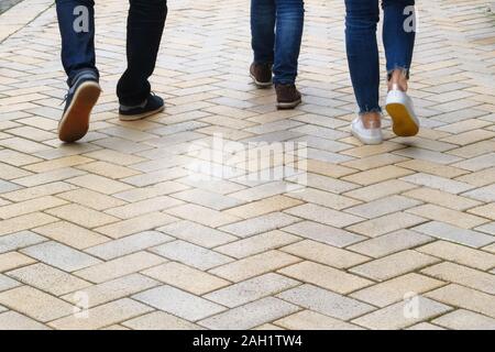 Die Menschen entlang der Fußweg. Gelbe ebnet Platte. Fußgängerzone im Park bei Tageslicht, Hintergrund. Städtische Promenade. Stockfoto