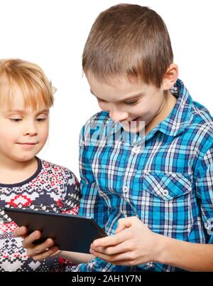 Junge spielt auf einem Touchpad mit kleinen Schwester Stockfoto