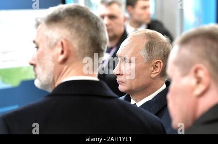 Taman, Russland. 23. Dezember, 2019. Der russische Präsident Wladimir Putin, Mitte, und Verkehrsminister Jewgeni Ditrikh, Links, eine Route Karte nach der Eröffnungsfeier für die Krim-Brücke Eisenbahnverbindung über die Straße von Kertsch verbinden auf der Krim, Krasnodar Dezember 23, 2019 in Taman, Russland. Die 19 km lange Brücke ist die längste in Europa und war fünf Jahre nach Russland im Anhang das Schwarze Meer Halbinsel. Credit: Aleksey Nikolskyi/Kreml Pool/Alamy leben Nachrichten Stockfoto