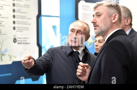 Taman, Russland. 23. Dezember, 2019. Russische Verkehrsminister Jewgeni Ditrikh, rechts, beschreibt den Umfang des Projekts zu Präsident Wladimir Putin, der nach der Eröffnung für die Krim-Brücke Eisenbahnverbindung über die Straße von Kertsch verbinden auf der Krim, Krasnodar Dezember 23, 2019 in Taman, Russland. Die 19 km lange Brücke ist die längste in Europa und war fünf Jahre nach Russland im Anhang das Schwarze Meer Halbinsel. Credit: Aleksey Nikolskyi/Kreml Pool/Alamy leben Nachrichten Stockfoto