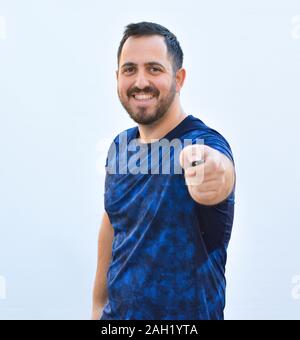 Junge lächelnde Mann mit Fernbedienung Stockfoto