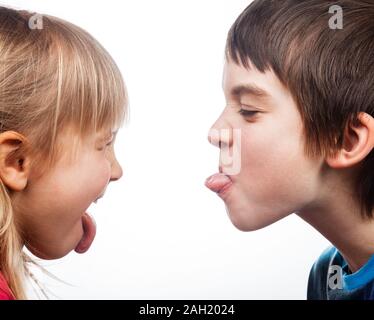 Nahaufnahme der Jungen und Mädchen heraus haften Zungen miteinander auf weißem Hintergrund. Kinder sind Halbgeschwister. Stockfoto