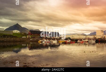 Eine bunte Perspektive der Fischerboote in einem Hafen an der Westküste von Island mit einem bewölkten und dramatischen Himmel. Angeln Konzept Stockfoto