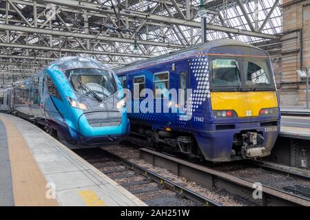 Eine Neue Transpennine Klasse 397 Nova elektrische Zug sitzt neben einer Klasse 320 Scotrail Zug in Glasgow Central Bahnhof Stockfoto