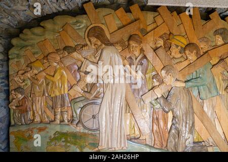 Ein Relief aus Holz schnitzen von Jesus sein Kreuz trug zusammen mit Menschen in allen Bereichen des Lebens. Das Heiligtum Unserer Lieben Frau von Tylicz. Stockfoto