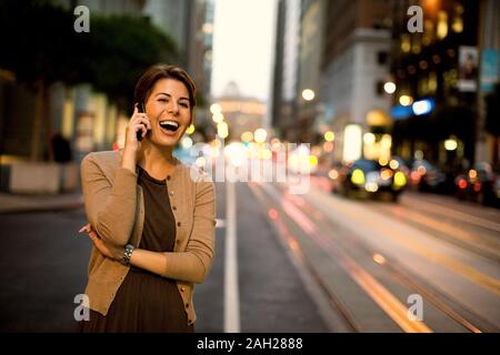 Zwei Kollegen sprechen beim Gehen hinunter eine städtische Straße. Stockfoto