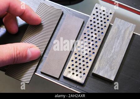 Ski tuning Dateien und Steine nebeneinander auf eine Basis zum Skifahren: panzar (Panzer) Datei, Mühle Datei, Diamant Stein, Keramik Stein. Diese sind für Ski und Schnee verwendet Stockfoto