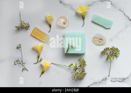 Organic Natural blue Seife für Spa oder Körperpflege mit wilden gelbe Blume auf weißem Marmor Stein Hintergrund Stockfoto