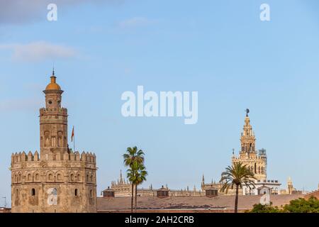 Goldene Turm (Torre del Oro) und Giralda Turm der Kathedrale von Sevilla bei Sonnenuntergang von der anderen Seite des Flusses Guadalquivir, Sevilla (Andalusien), Spai Stockfoto