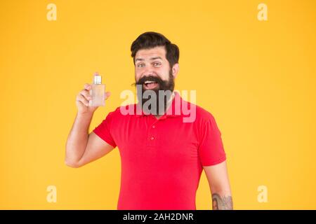 Parfüm für Männer nach Anlass wählen. Stellen Sie sicher, dass der Geruch frisch den ganzen Tag. Vorteile von Parfums. Mann gut gepflegt Bärtigen stattlichen Halten Sie Flasche Parfüm. Frische Konzept. Das Tragen von Parfüm. Stockfoto