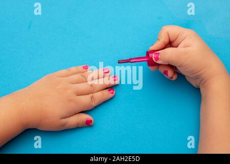 Kinder Maniküre. Kinder malen ihre Hände Nägel mit bunten Nagellack. Red Maniküre auf kindliche Nägel. Stockfoto